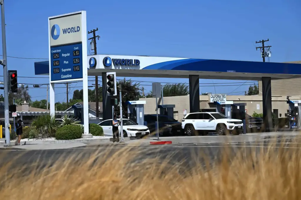 Customers fill up their gas tanks at a World Oil...