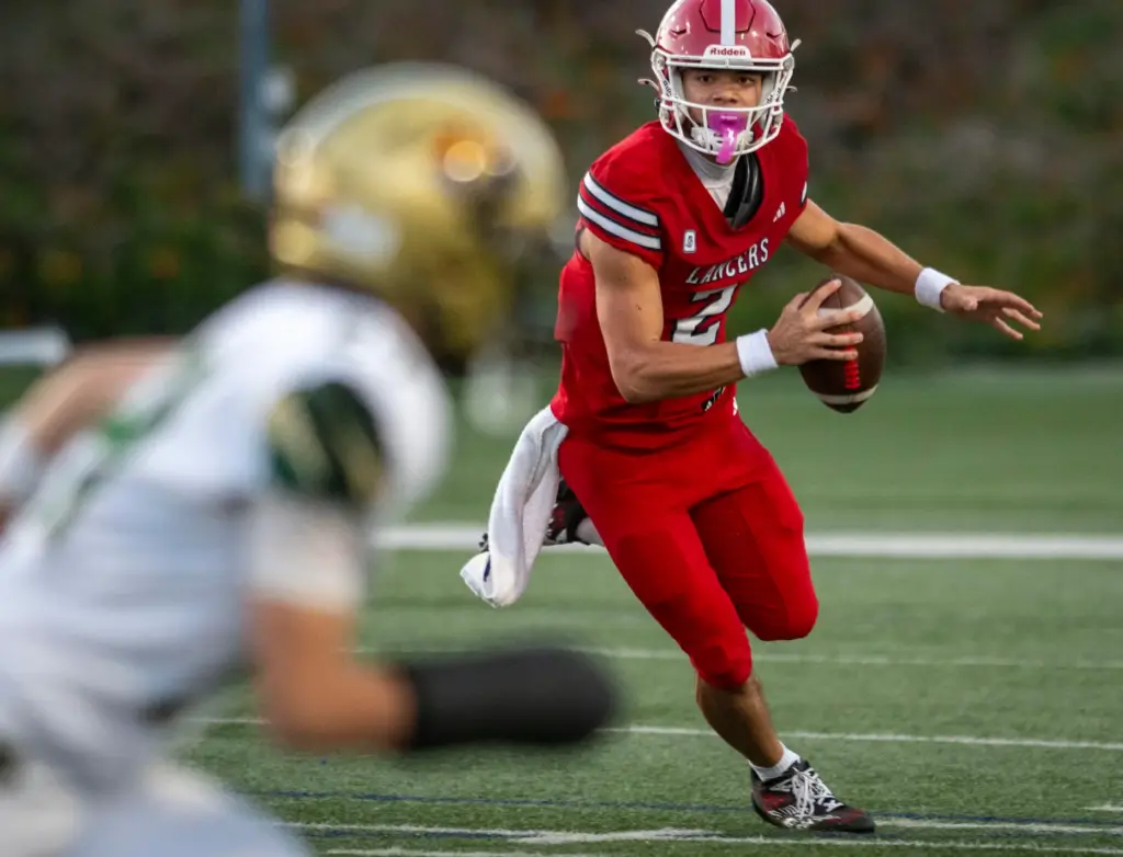 Orange Lutheranâs Reagan Toki (2) scramble for yardage during a...