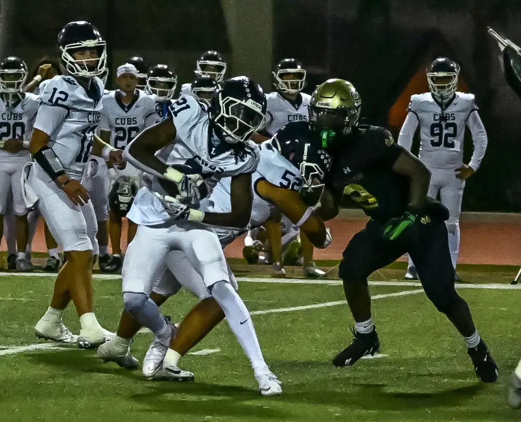 Loyola High running back Jayden Rogers rushes with the ball...