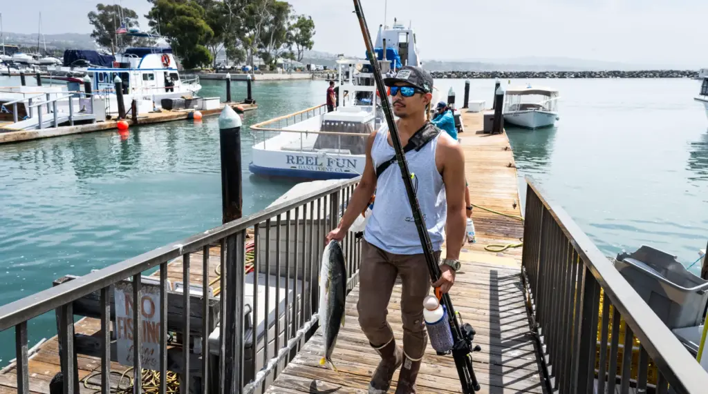 Joseph Harker of Irvine carries the yellowtail he caught while...