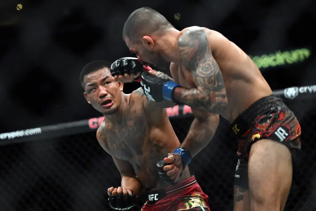 Flyweight champion Joshua Van (red) lands a punch on Alexandre...