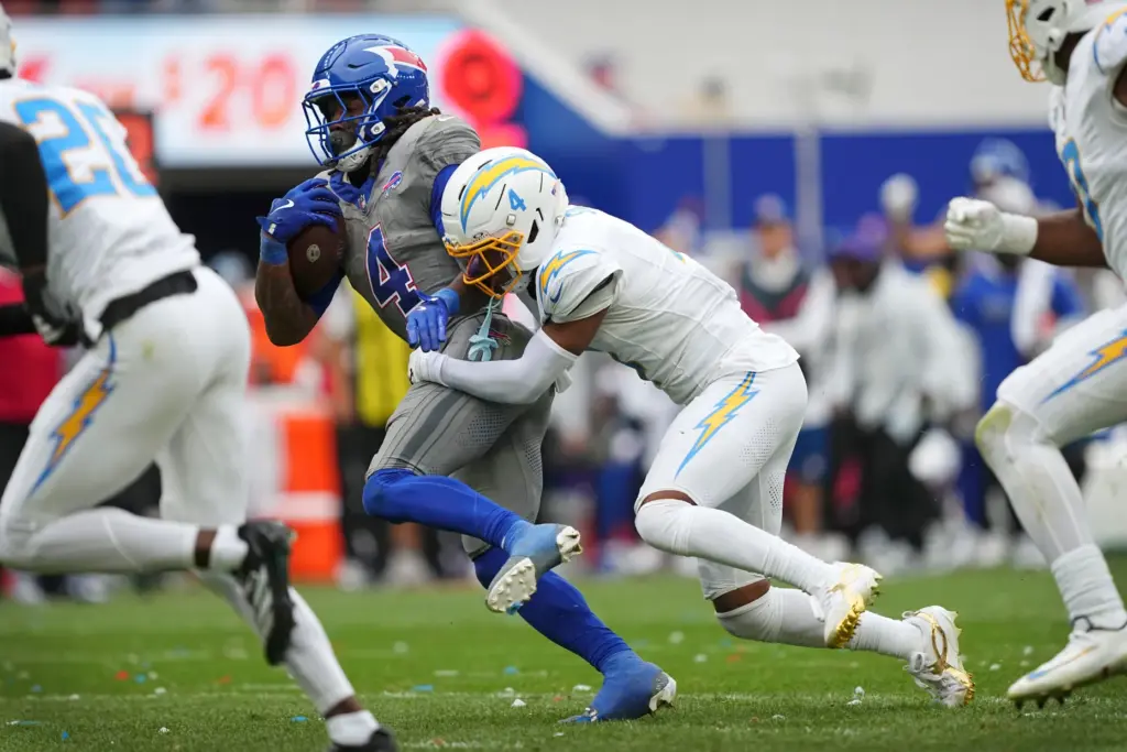 Buffalo Bills running back James Cook III, left, tries to...