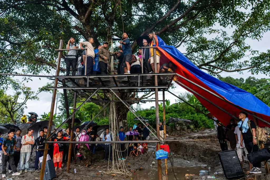 Residents pull the steel wire of a newly installed zipline.