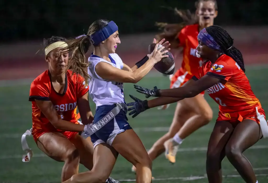 Beckman quarterback Marina Babayani, center, picks up some yardage before...