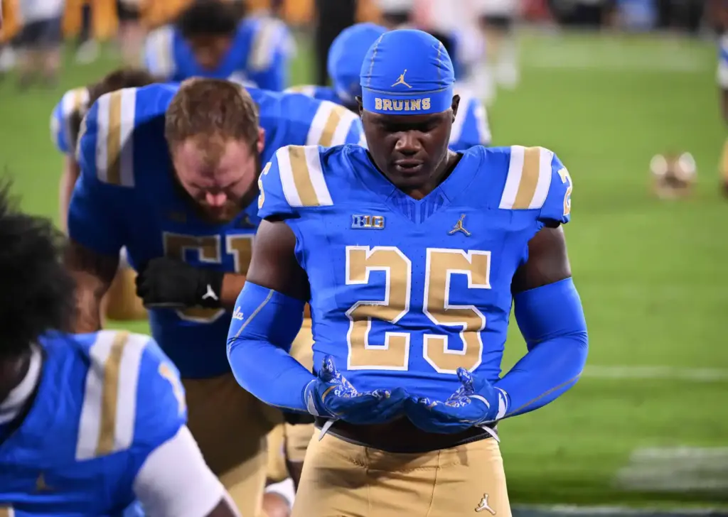 UCLA Bruins take a moment prior to a NCAA football...