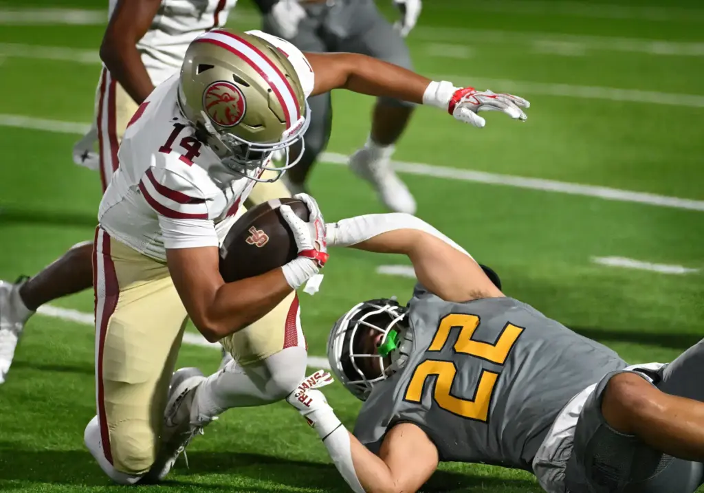JSerra Kai Taylor (14) holds onto the ball as Crean...