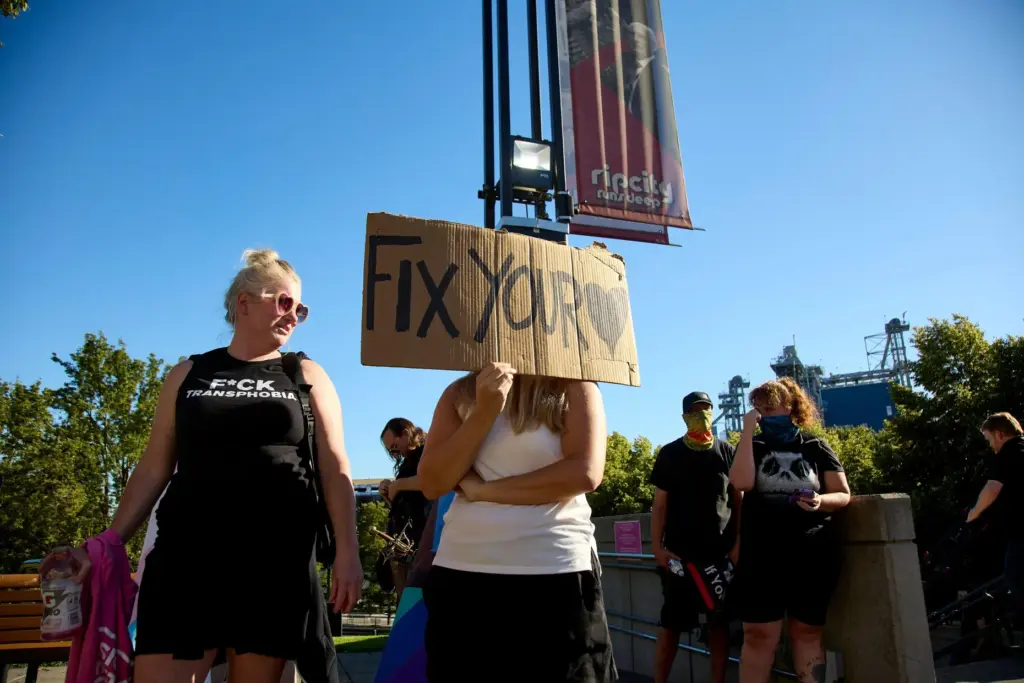 FILE – A woman holds a sign supporting trans people...