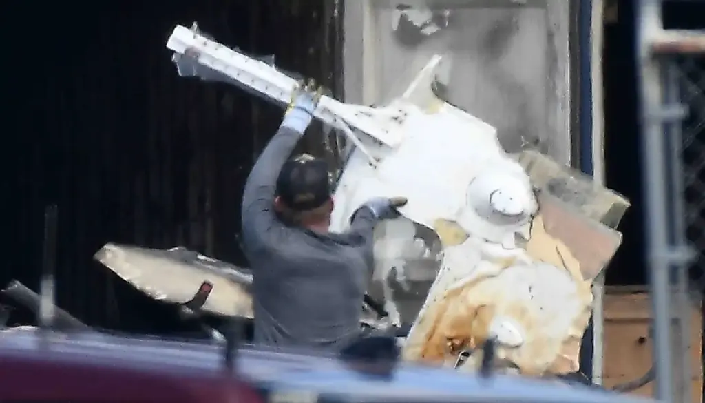 Salvage crews help NTSB investigators remove of whatâs left of...