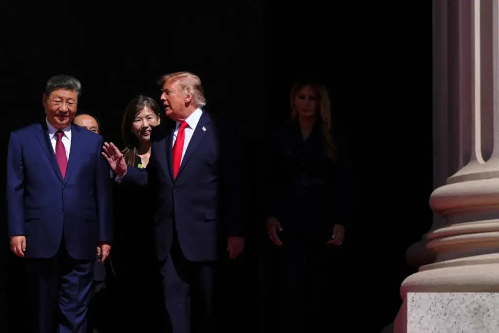 President Donald Trump, center, speaks with China’s President Xi Jinping...