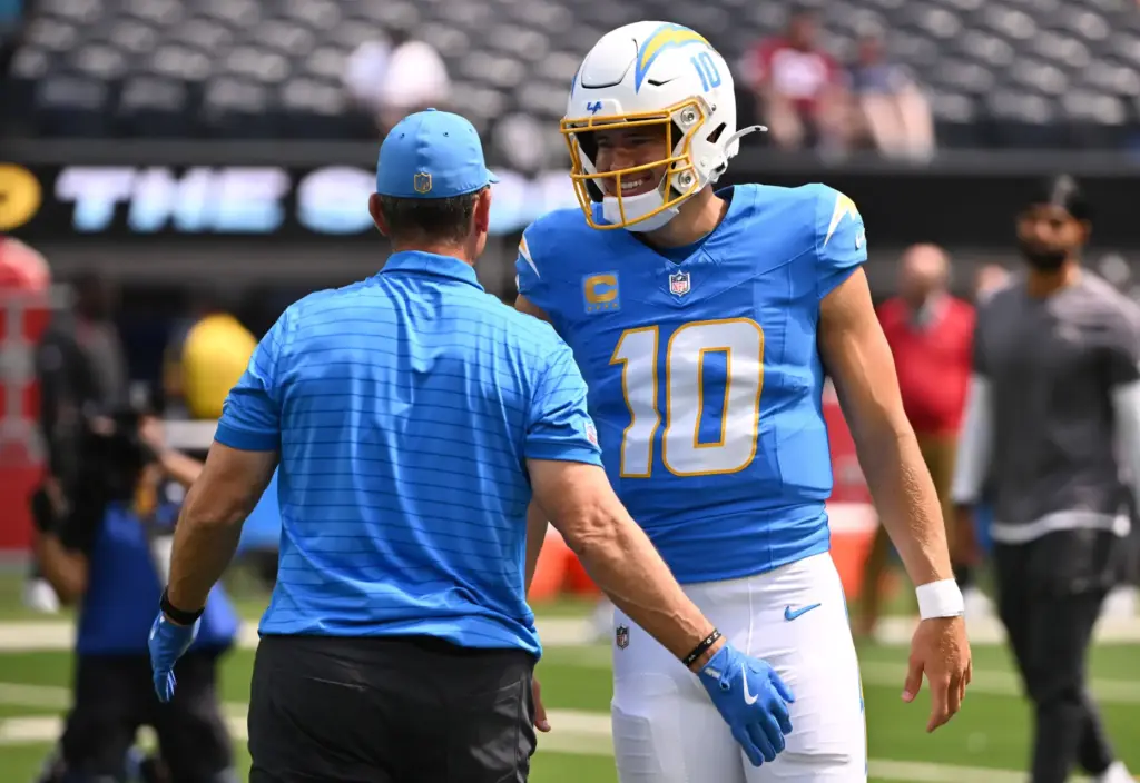 Chargers quarterback Justin Herbert (10) with head coach Jim Harbaugh...