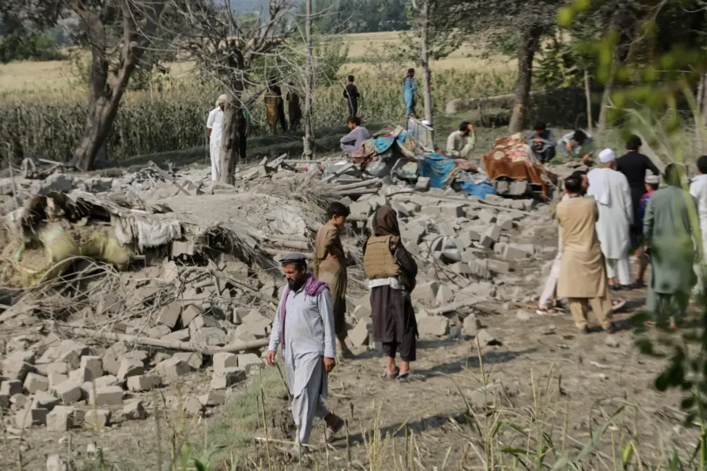 Residents inspect the rubble of a house destroyed in a...