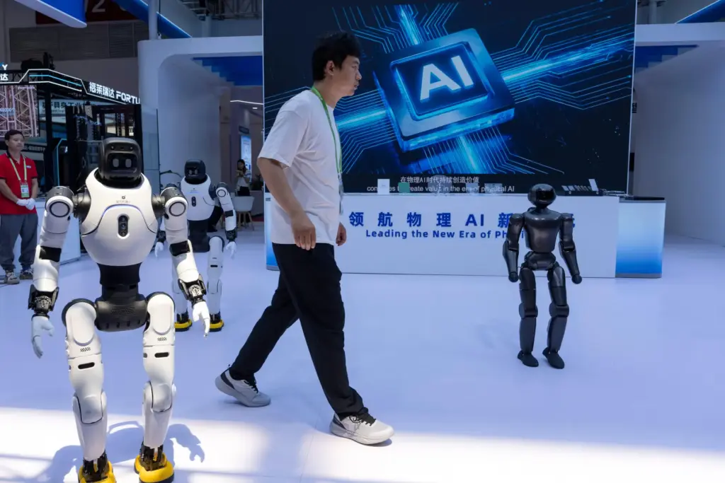 A worker passes by robots from Chinese company Lens at the China International Supply Chain Expo.