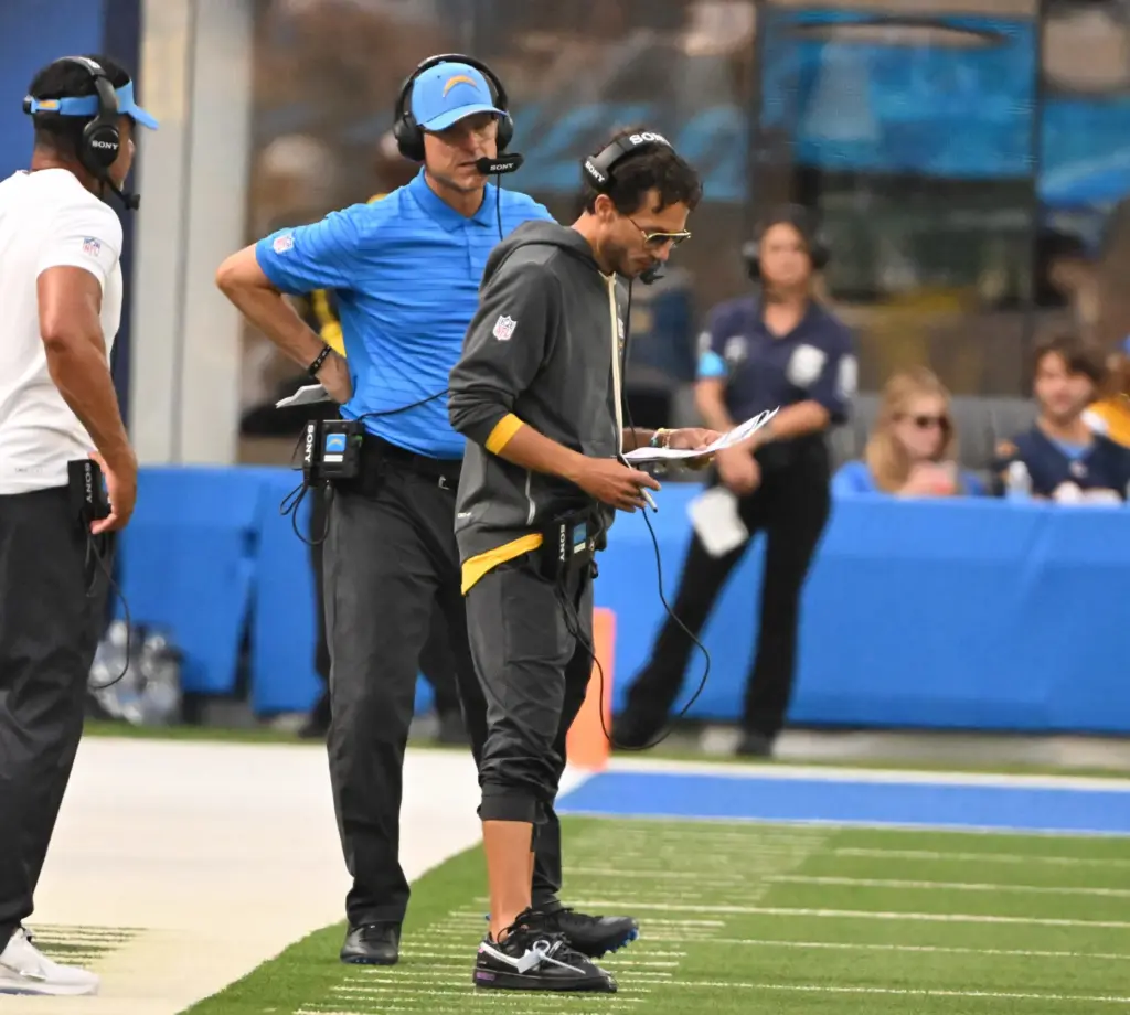 Chargers offensive coordinator Mike McDaniel, right, looks over notes as...
