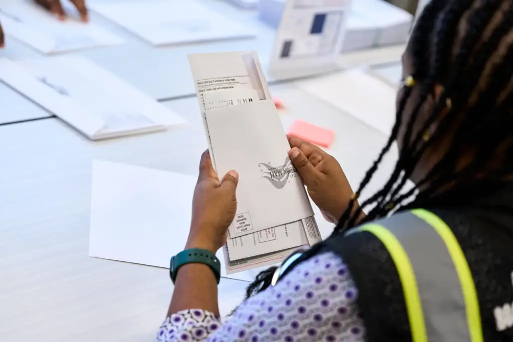 Wake County Board of Elections employees prepare absentee ballots to...