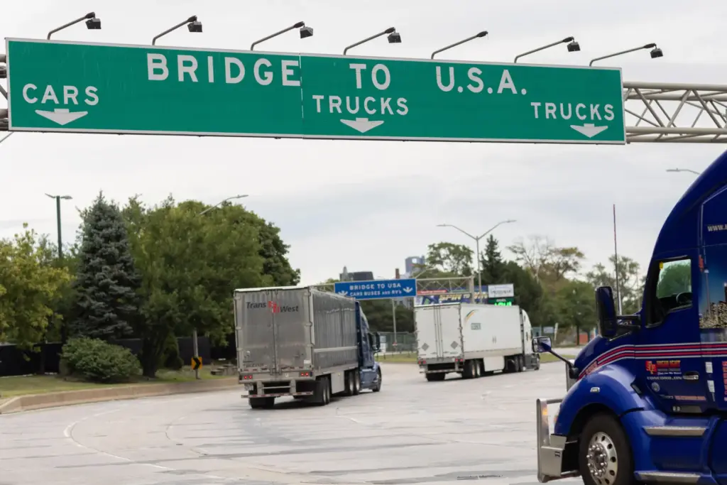 Transport trucks cross the Ambassador Bridge into the United States...