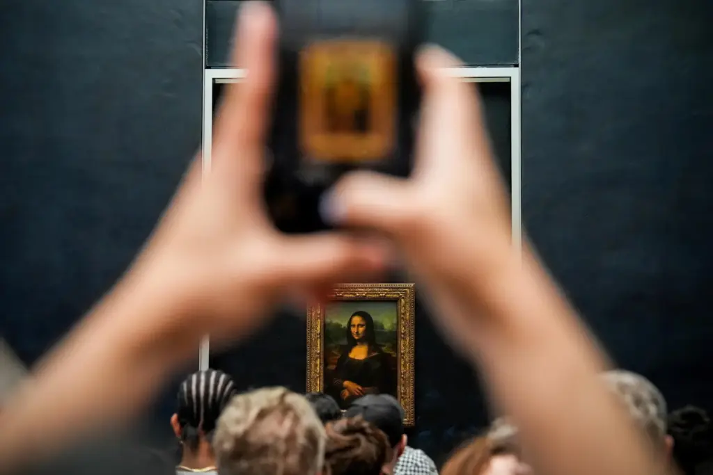 FILE – A person photographs Leonardo da Vinci’s painting Mona...