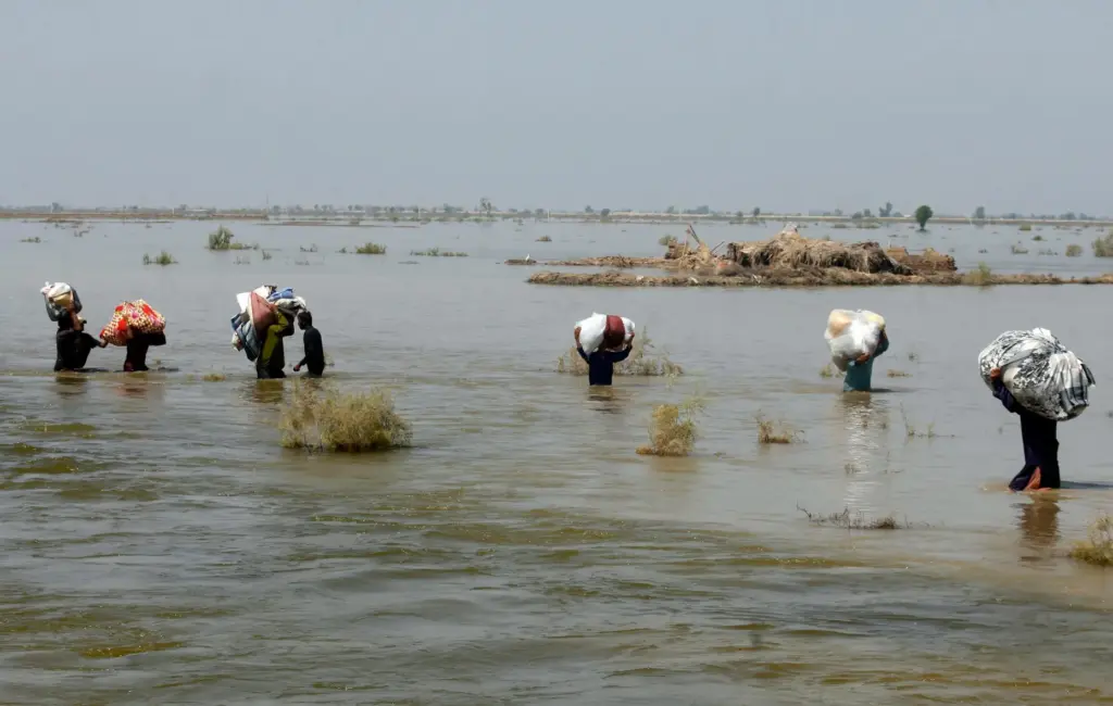 FILE – Victims of heavy flooding from monsoon rains carry...