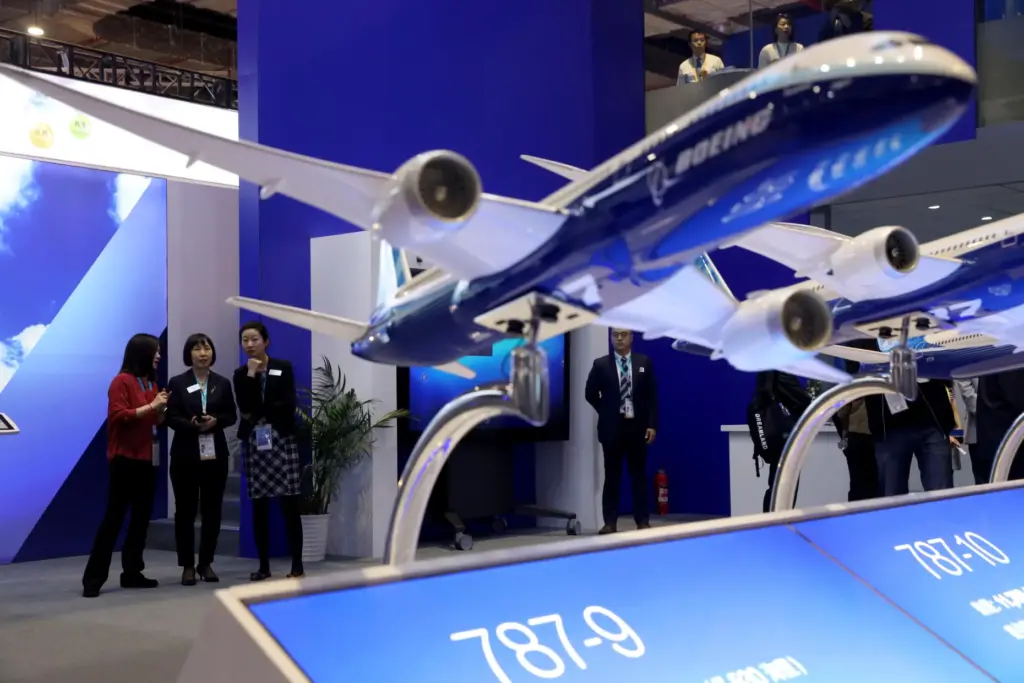 Visitors chat near models of Boeing passenger jets displayed at the China International Import Expo.