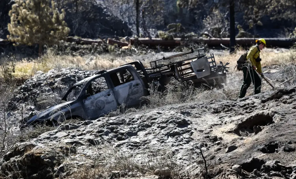 A firefighter works next to a firefighting rig that was...