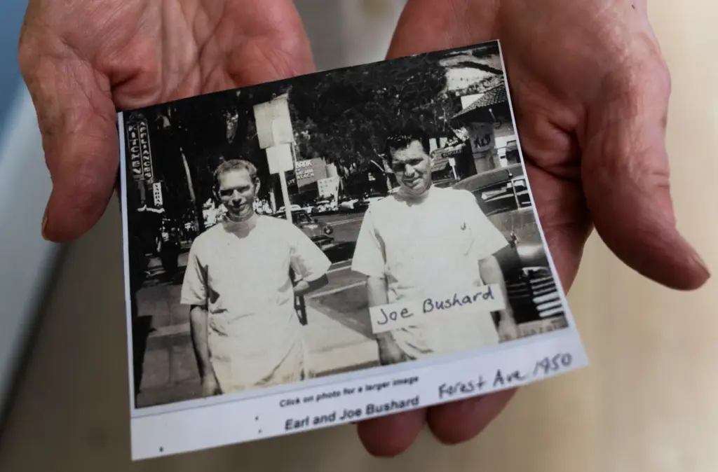 Sheila Bushard-Jamison holds a photo of her dad, Joe Bushard,...