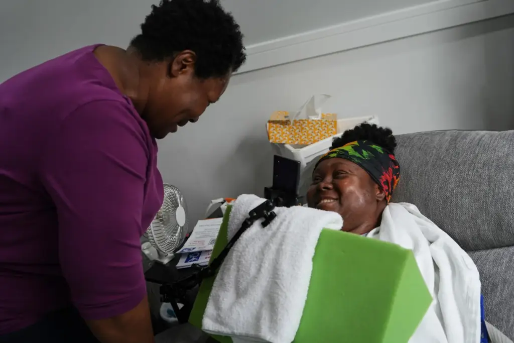Jacqueline Davis and her daughter, Ebony Payne, a disability advocate who is quadriplegic, laugh at their home.
