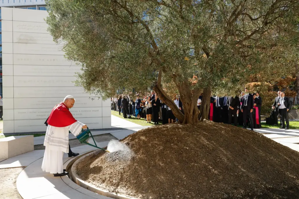Pope Leo waters a olive tree alongside UNESCO Director-General Khaled El-Enany.