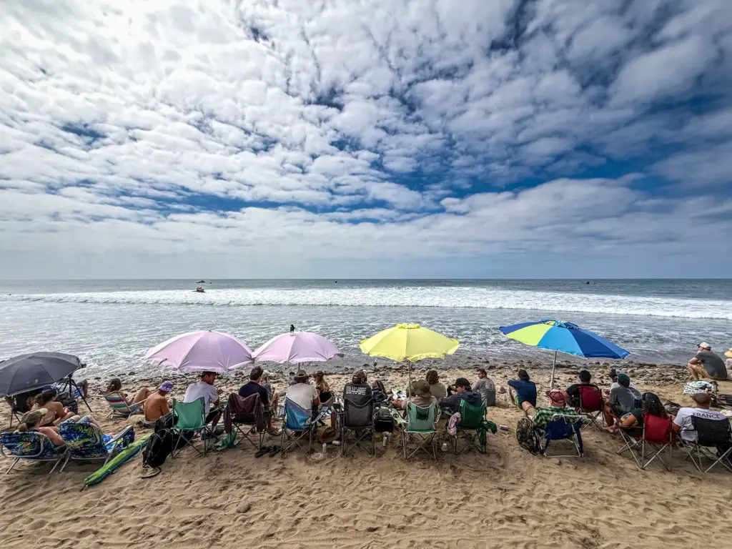 Beach goers watch the Trestles Pro in San Clemente, CA,...