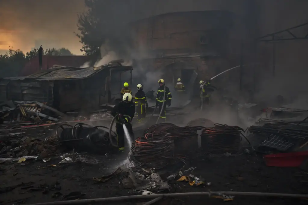 Firefighters try to extinguish a fire following a Russian missile...