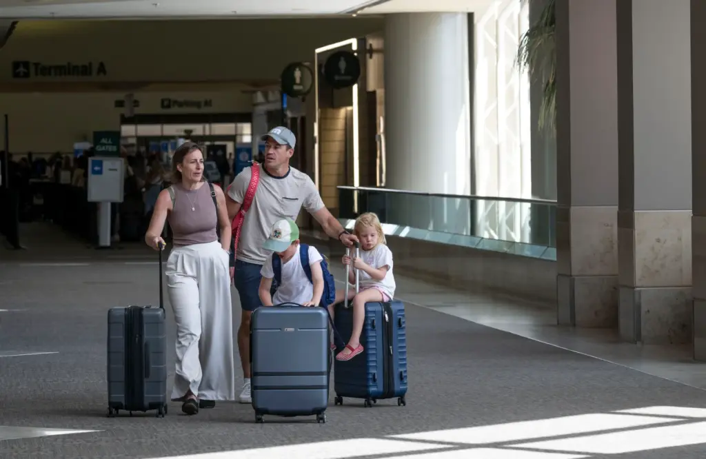 Travelers walk between terminals at John Wayne Airport in Santa...