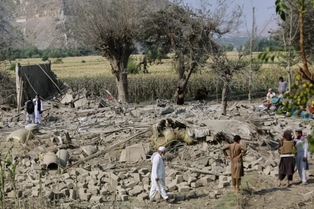 Residents inspect the rubble of a house destroyed in a...