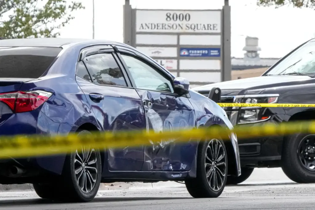 A vehicle with a damaged door and broken window is...