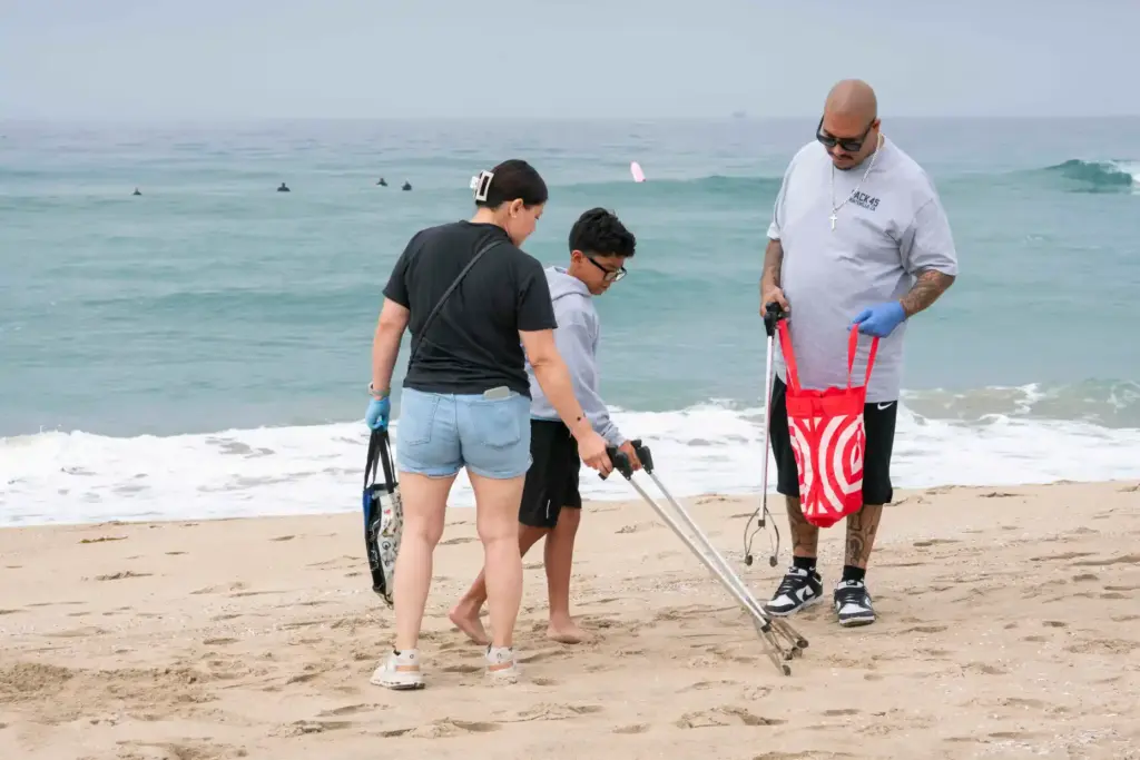 Veronica Maldonado and Adrian and Steve Arguello retrieve a piece...