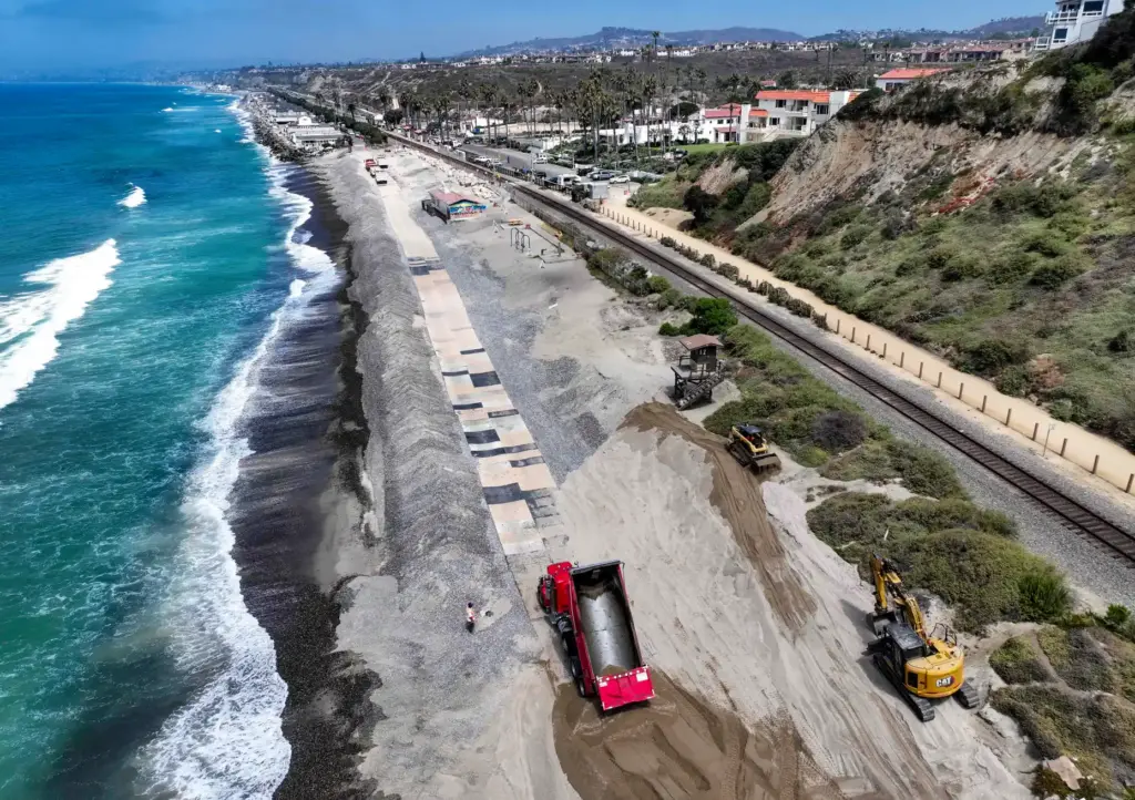 Workers replenish sand on North Beach in San Clemente, CA,...