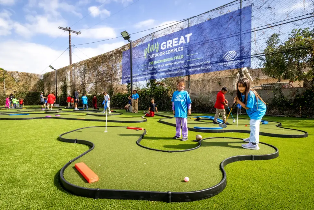 Madelyn Arrueta, 7, practices her golf putting skills as her...