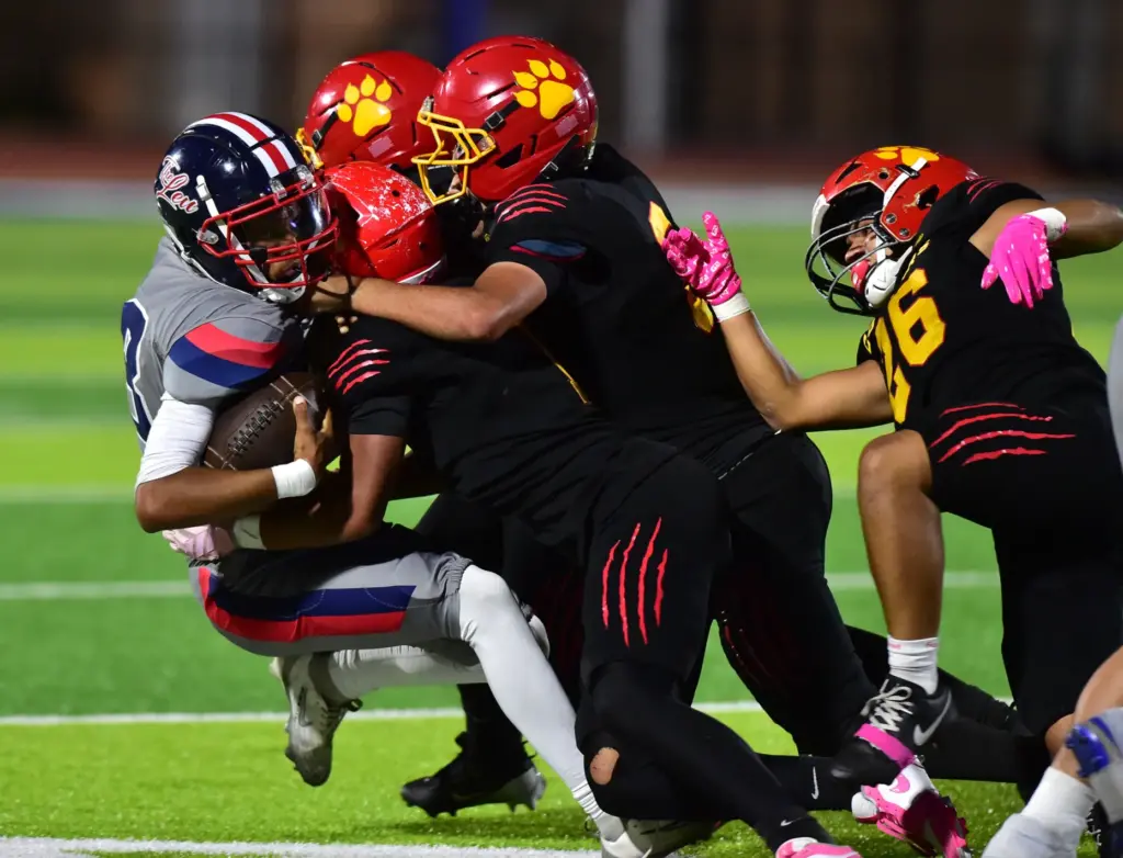 Leuzinger QB Max Leyva gets sacked by Hawthorne defenders in...
