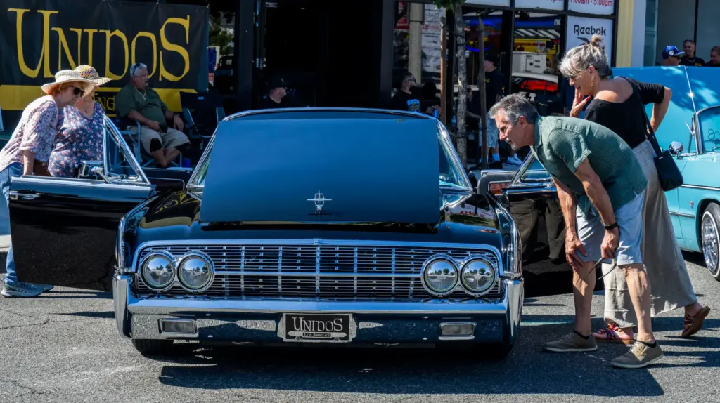 Classic car enthusiasts look over Eduardo Floresâ black 1962 Lincoln...