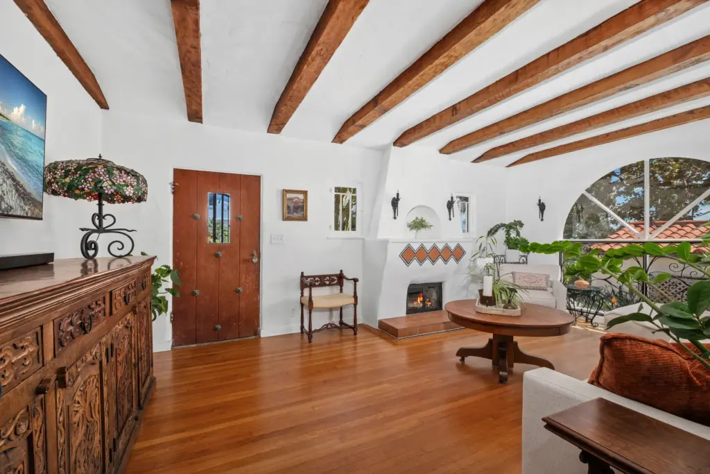 A stucco fireplace with geometric diamond-tile inlay and a raised...
