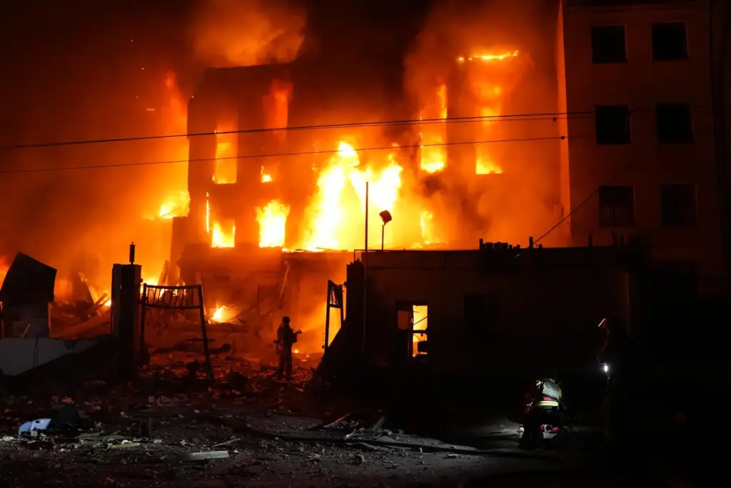 A rescue worker puts out a fire of a building...