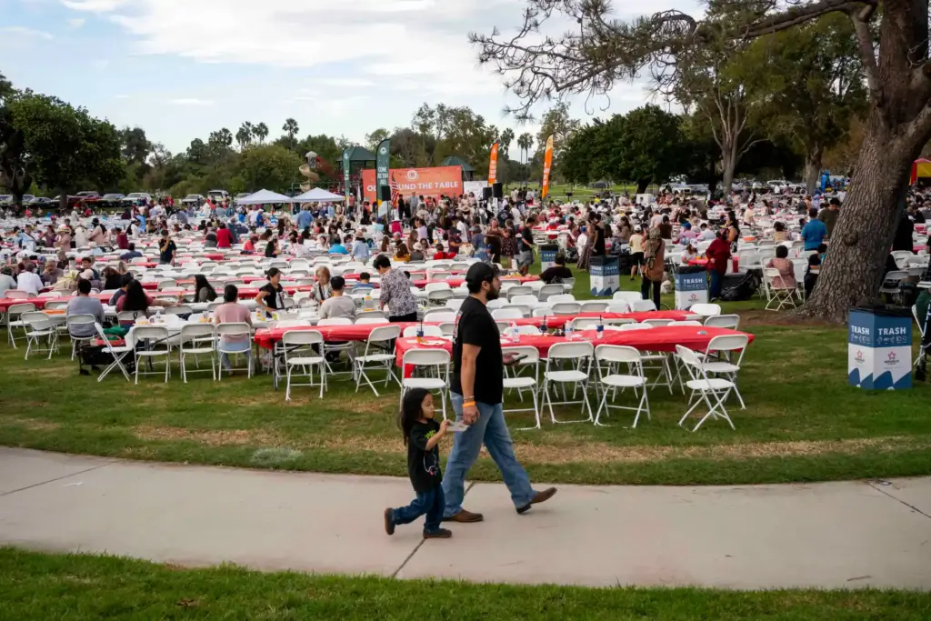 Potluckgoers walk around the OC Around the Table community potluck...
