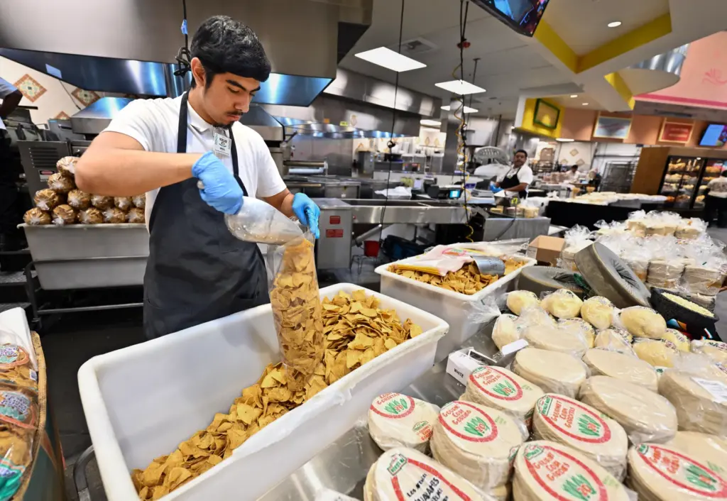 Xavier Alemparte fills bags of fresh chips during opening day...