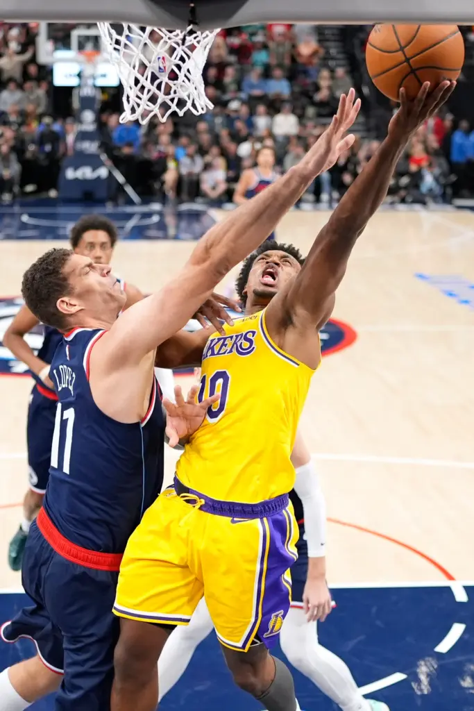 Lakers guard Collin Sexton, right, shoots as Clippers center Brook...