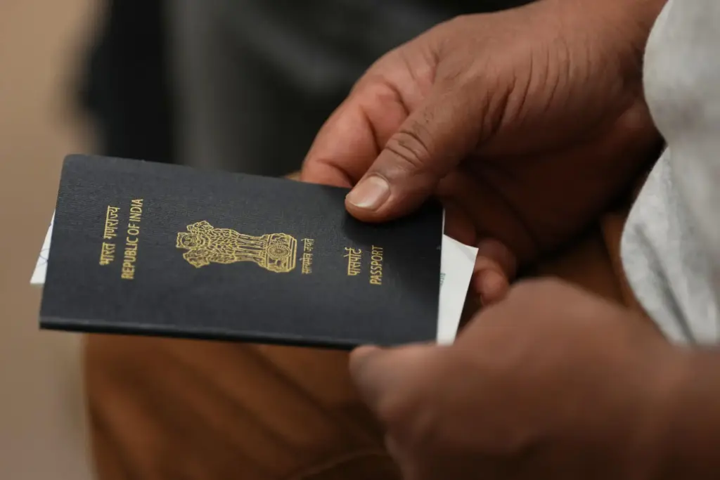 A worker holds his passport in a hotel conference room...