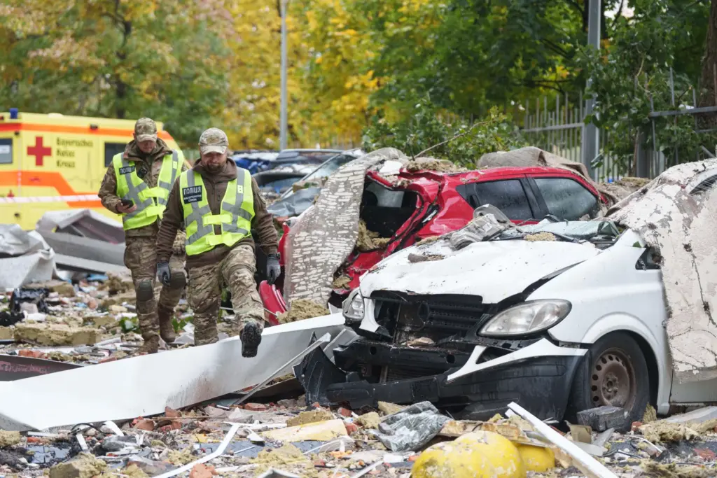 Policemen walk in front of destroyed cars after a Russian drone strike.