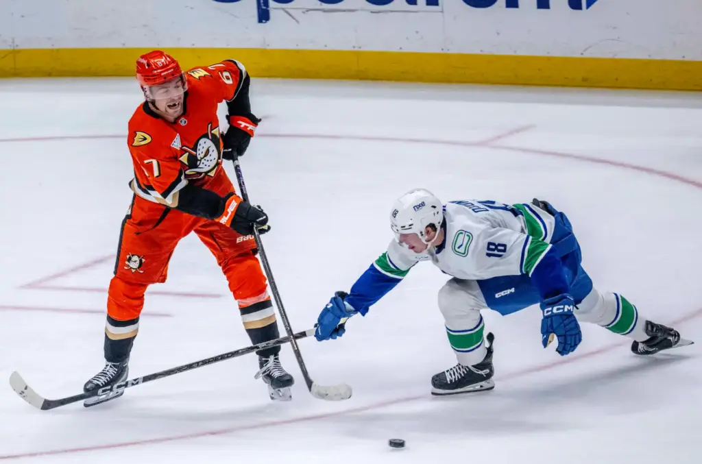 The Ducksâ Tristan Luneau, left, passes the puck up the...