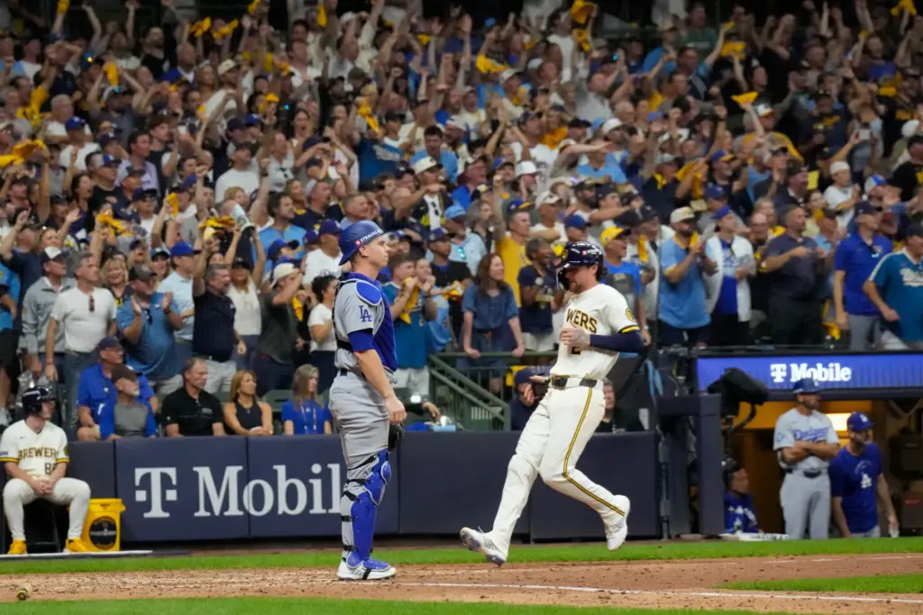 The Milwaukee Brewers’ Brice Turang, right, scores on a single...