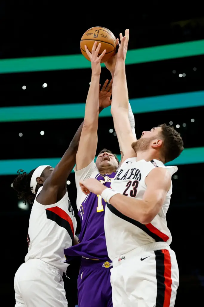 Portland Trail Blazers guard Jrue Holiday, left, Lakers center Walker...