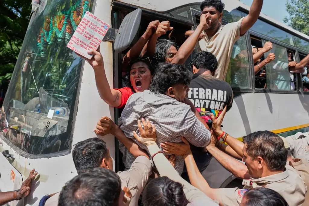 Socialist, left-wing parties and student activists shout slogans from a police vehicle.