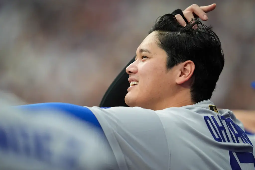 Dodgers star Shohei Ohtani watches from the dugout during the...