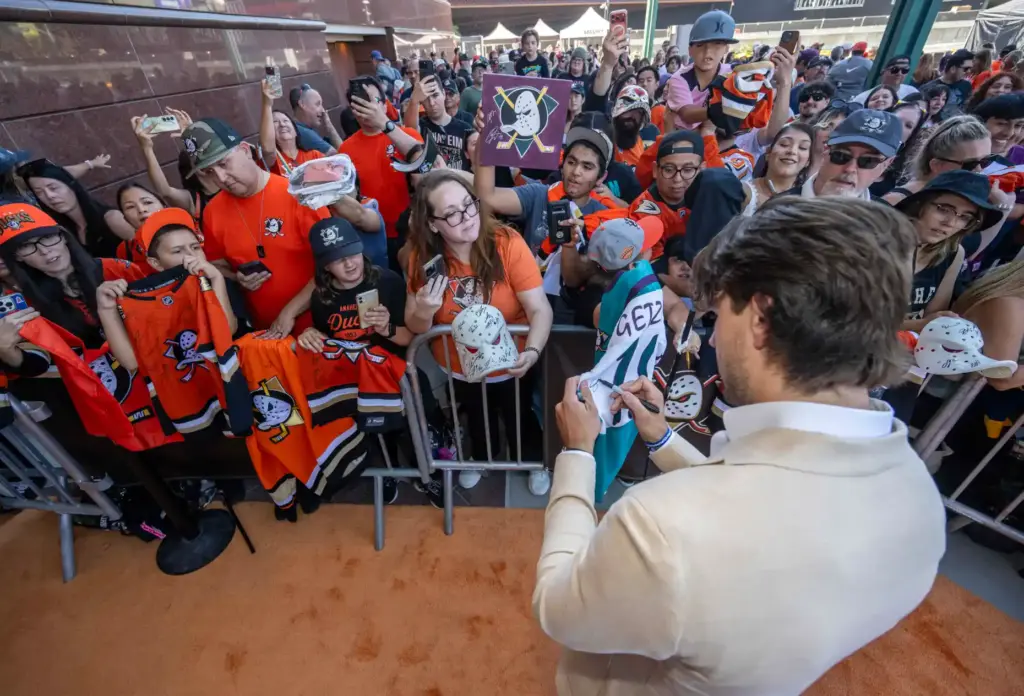 Ducks player Cutter Gauthier signs autographs on the orange carpet...