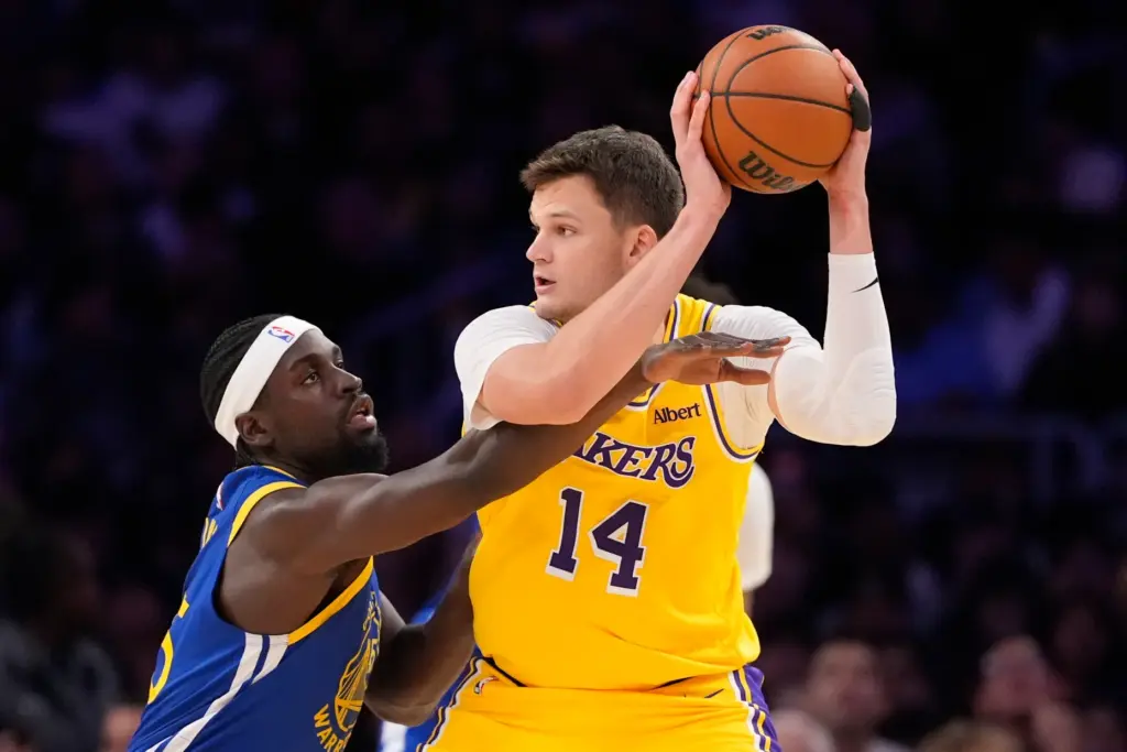 Lakers center Walker Kessler, right, looks to pass the ball...